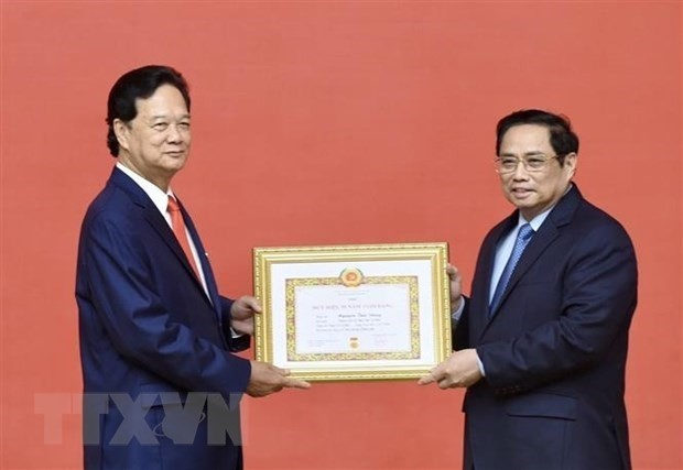 Le Premier ministre Pham Minh Chinh (à droite) remet l’Insigne des 55 ans d’adhésion au PCV à l’ancien Premier ministre Nguyên Tân Dung. Photo : VNA.