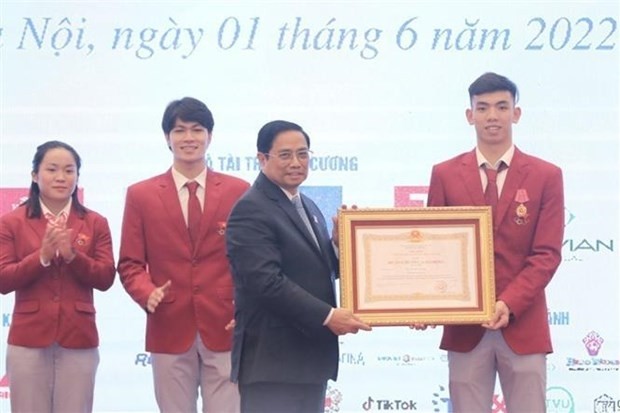 Le Premier ministre vietnamien, Pham Minh Chinh (à gauche), décerne l'Ordre du Travail de deuxième classe au sportif Nguyên Huy Hoàng (natation). Photo : VNA.