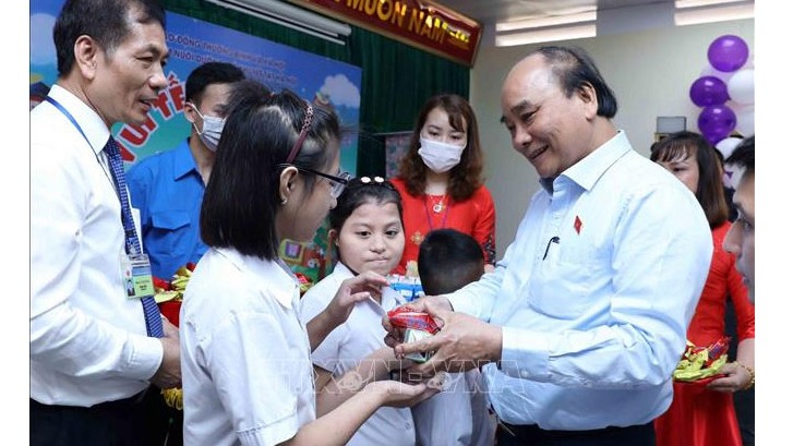 Le Président vietnamien, Nguyên Xuân Phuc (à droite), remet des cadeaux aux enfants du Centre de soins aux enfants handicapés de Hanoï. Photo : VNA.