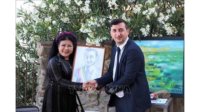 La femme peintre Van Duong Thanh remet un cadeau au maire de la ville de Passignano Sandro Pasquali. Photo : VNA.