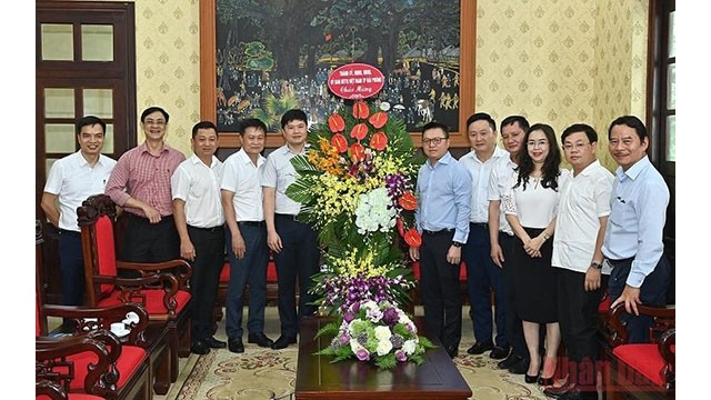 Les dirigeants de Hai Phong offrent des fleurs aux représentants du Journal Nhân Dân. Photo : NDEL.