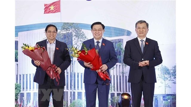 Le président de la Commission des sciences et technologies et de l’environnement de l'Assemblée nationale, Lê Quang Huy (à droite), offre des fleurs au Premier ministre Pham Minh Chinh (à gauche) et au Président de l'Assemblée nationale Vuong Dinh Huê (au milieu). Photo : VNA.