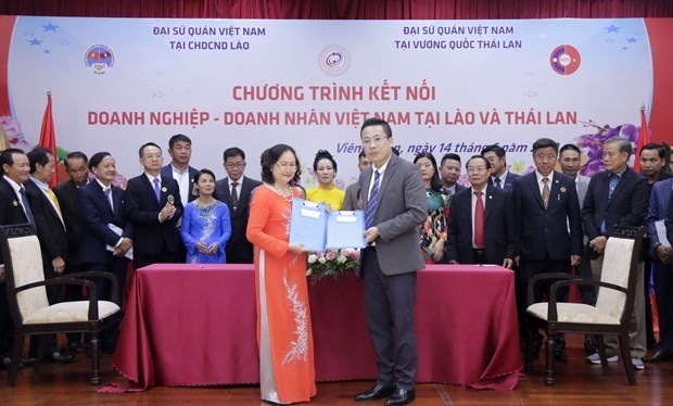 Les entreprises vietnamiennes au Laos et en Thaïlande échangent des protocoles de coopération commerciale signés lors du forum. Photo : VNA.
