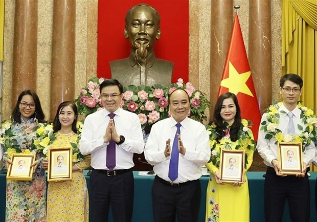Le Président Nguyên Xuân Phuc (3e à droite) offre un portrait du Président Hô Chi Minh aux travailleurs exemplaires du pétrole et du gaz en 2017 - 2022, à Hanoi, le 25 juin. Photo : VNA.