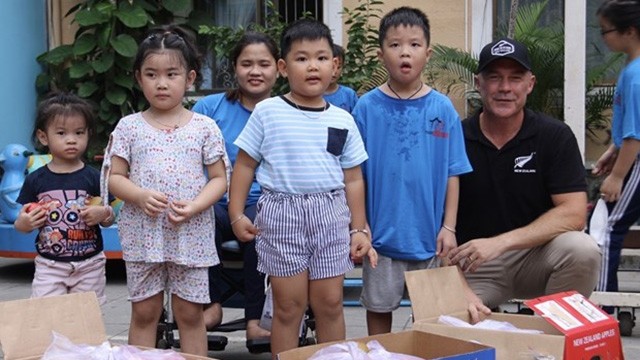 Le consul général de Nouvelle-Zélande à Hô Chi Minh-Ville, Joe Nelson, fait don de fruits aux enfants au Village Chance. Photo : VNA.