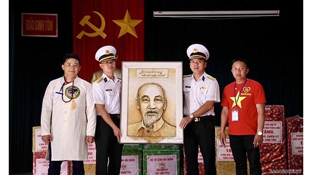 Le président de l'Association vietnamienne en Mongolie, Nguyên Huy Tuân (à gauche), offre la photo du Président Hô Chi Minh aux soldats et aux habitants de Truong Sa. Photo : baoquocte.vn