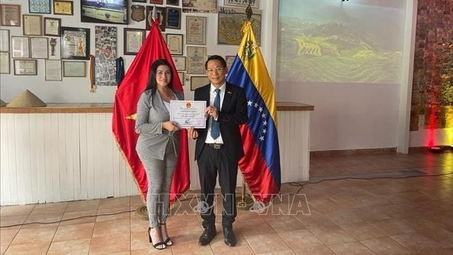 L’ambassadeur du Vietnam au Venezuela Lê Viêt Duyên (à droite) remet un certificat à la propriétaire de Heladería 1000 sabores Isbellis Da Silva. Photo : VNA