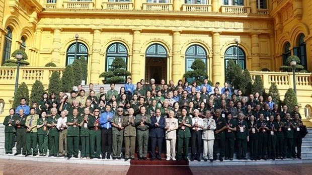 Le Président vietnamien, Nguyên Xuân Phuc, pose avec d’anciens jeunes volontaires modèles à Hanoi, le 26 juillet. Photo : VNA.