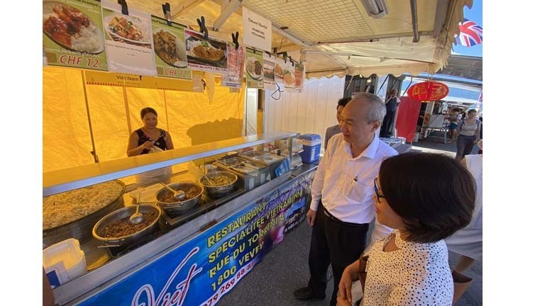 L'ambassadeur du Vietnam en Suisse Phung Thê Long visite le stand du restaurant Maison Viet. Photo: VNA