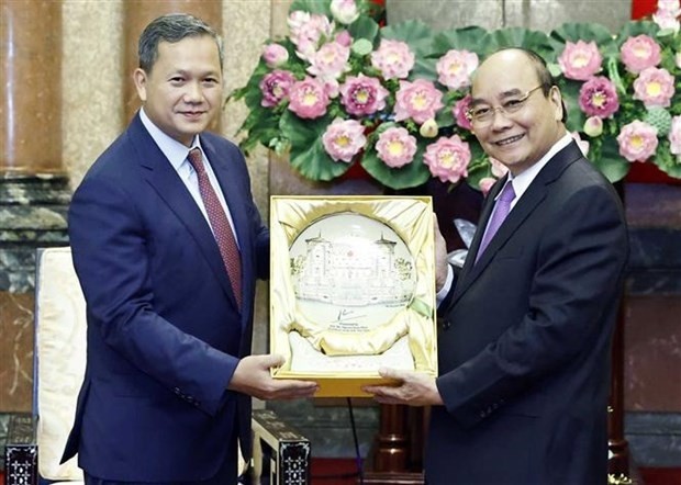 Le Président vietnamien, Nguyên Xuân Phuc (à droite), offre un souvenir au général d’armée cambodgien Hun Manet. Photo : VNA.