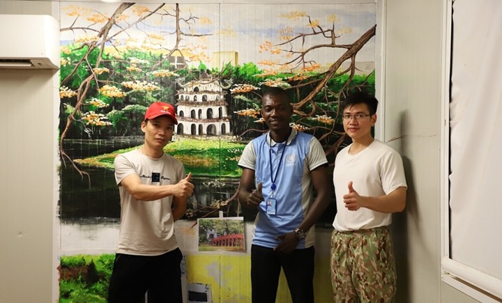 Des membres de l'hôpital et un peintre ghanéen décorent la salle de réception internationale. Photo : QDND.