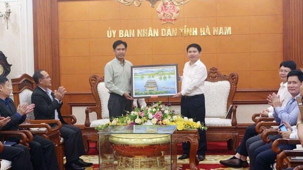 Le ministre de la Justice du Laos, Phayvy Xibualypha (à gauche), offre un cadeau au président du Comité populaire de la province de Ha Nam, Truong Quôc Huy. Photo: VNA
