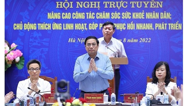 Le Premier ministre Pham Minh Chinh (debout au 1er rang lors de la téléconférence nationale sur le secteur médical, le 21 août. Photo : VNA.