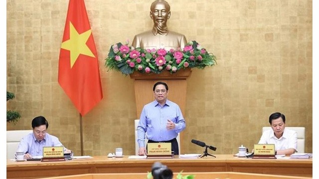 Le Premier ministre Pham Minh Chinh (debout) à la réunion périodique du gouvernement d’août portant sur l'édification de la loi. Photo : VNA.