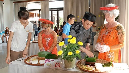 Des touristes étrangers préparent le "banh chung" pour le Têt. Photo: baobinhthuan.com.vn